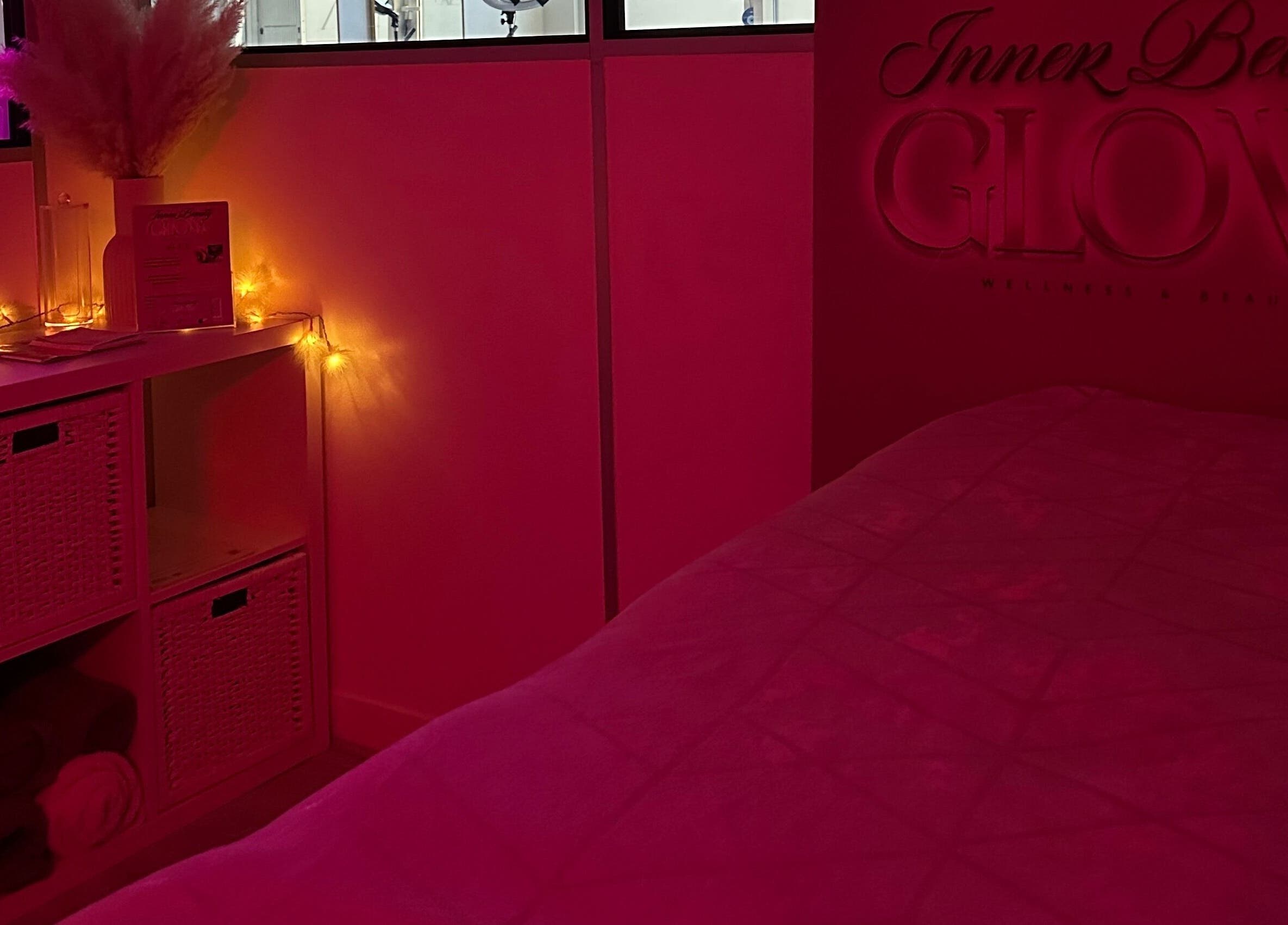 Cozy, warmly-lit treatment room at Inner Beauty Glow, London, England, GB with ambient lighting and decor.