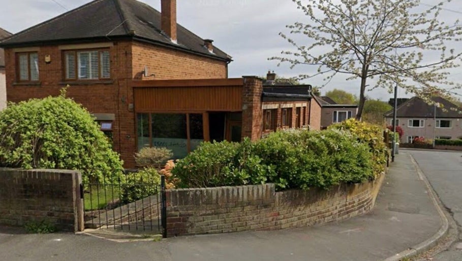 Exterior of Hair by Sienna, a stylish salon in Northowram, England, GB, surrounded by lush greenery.