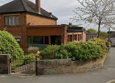 Exterior of Hair by Sienna, a stylish salon in Northowram, England, GB, surrounded by lush greenery.
