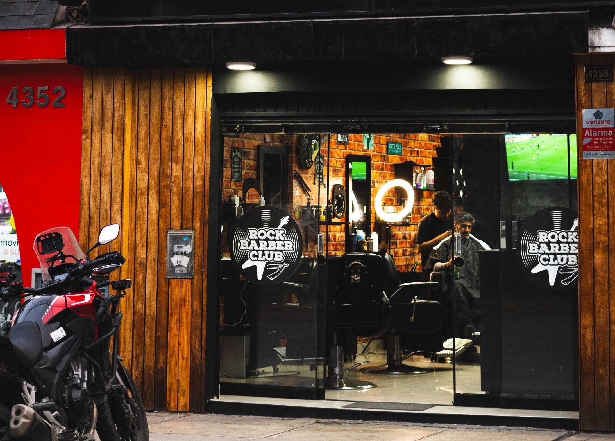 Entrada de Rock Barber Club en Surquillo, Provincia De Lima, PE con motocicleta estacionada afuera.