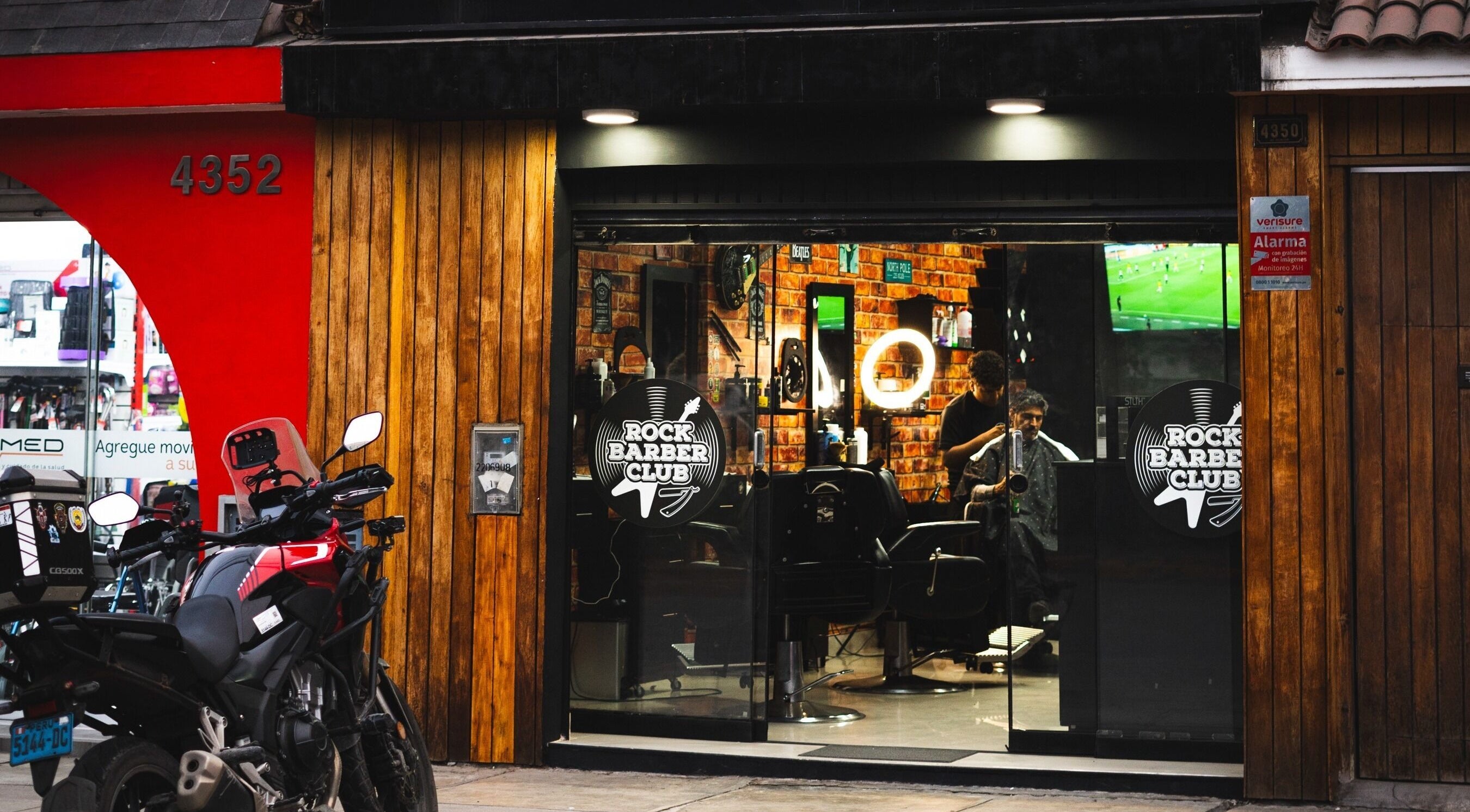Entrada de Rock Barber Club en Surquillo, Provincia De Lima, PE con motocicleta estacionada afuera.