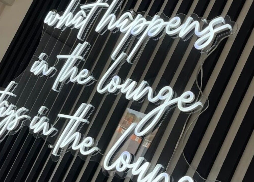 Semn luminos negru și alb la Vivi Nails, Derby, England, GB, creând o atmosferă unică.