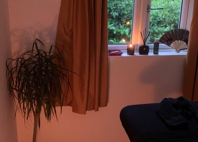 Relaxing treatment room at Holistic With Holly, Selling, England, GB with candles and a massage bed.