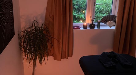 Relaxing treatment room at Holistic With Holly, Selling, England, GB with candles and a massage bed.