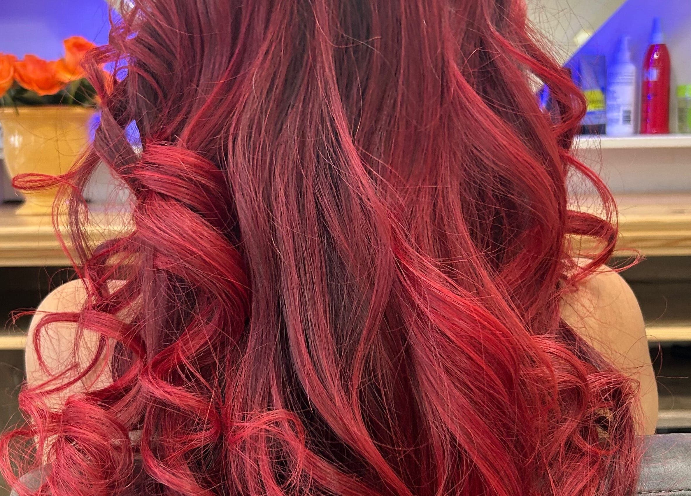 Vibrant curled red hair styled at HairPrecisionByDaniela, London, England, GB. Showcasing salon's expert styling.