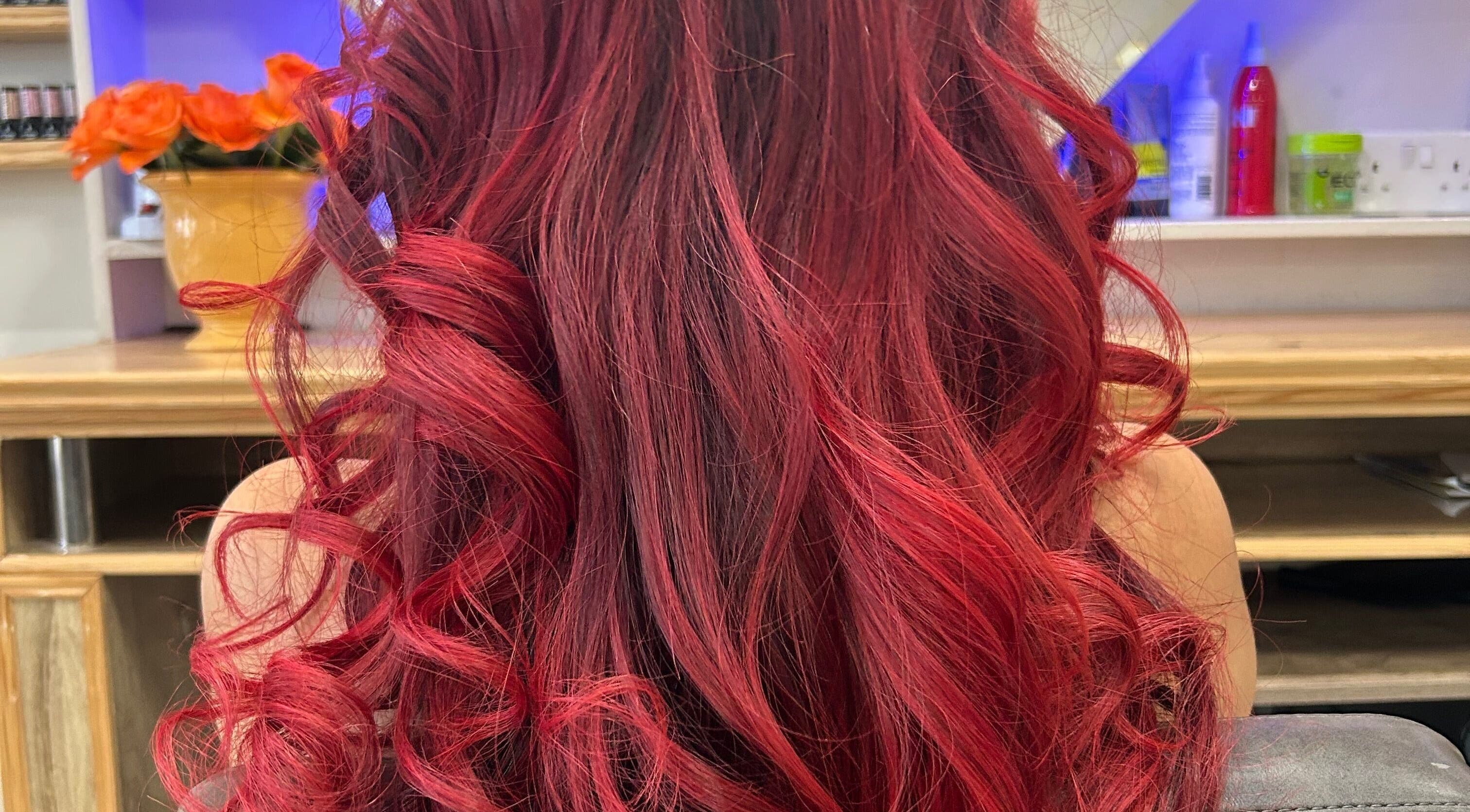 Vibrant curled red hair styled at HairPrecisionByDaniela, London, England, GB. Showcasing salon's expert styling.