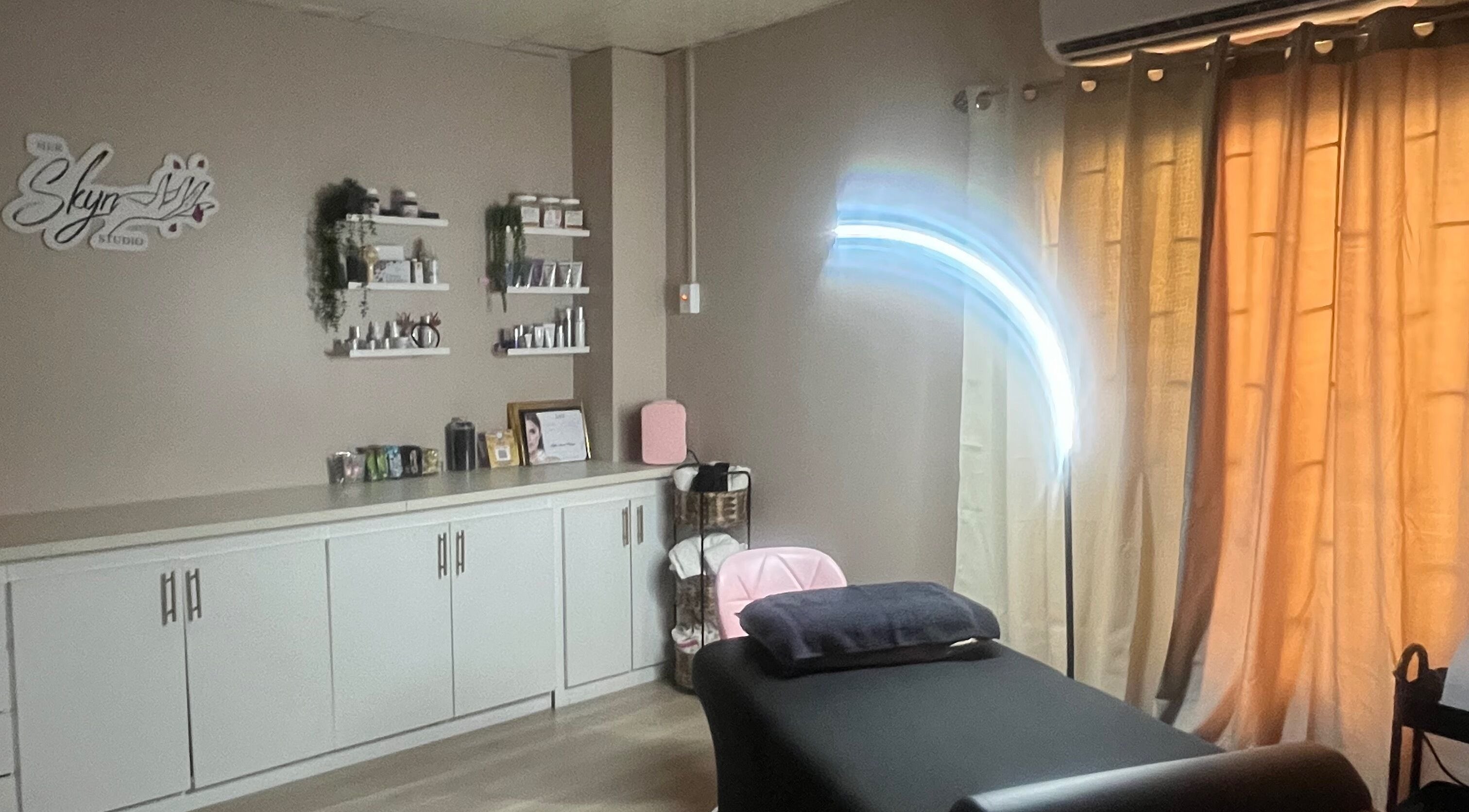 Tranquil treatment room at SKYN BY SOPHIA AESTHETICS in Chaguanas, TT, featuring a cozy massage table.