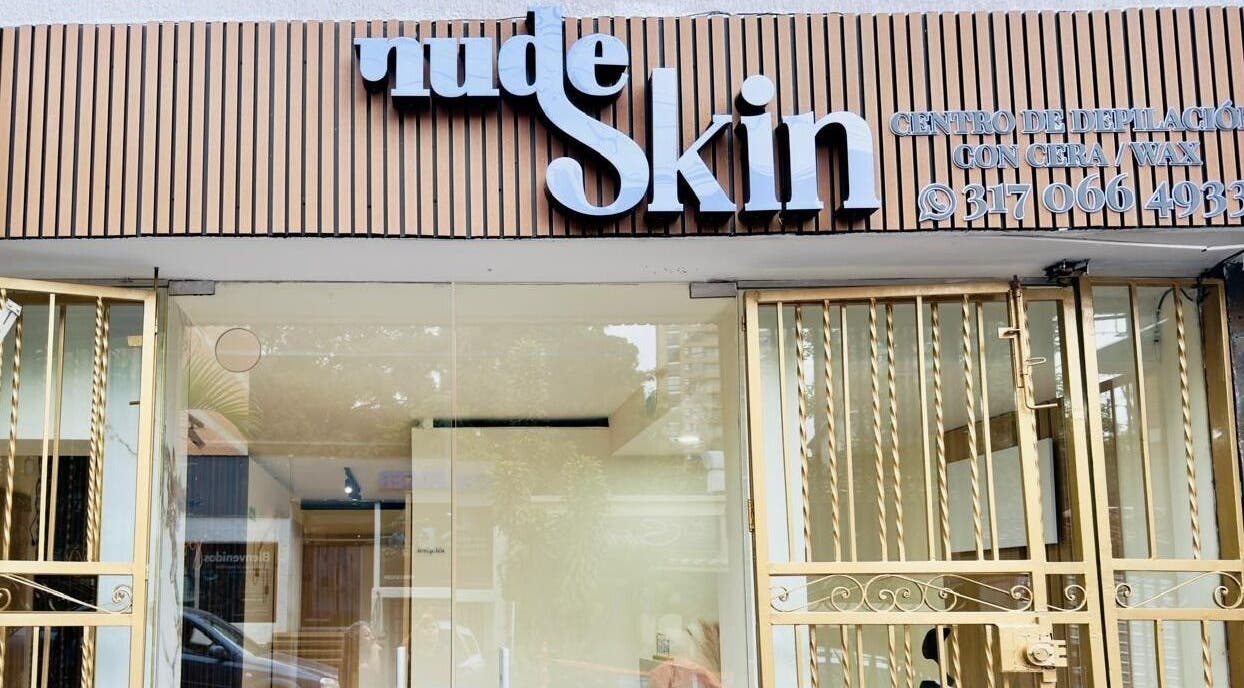 Fachada de Nudeskinwaxing en Medellín, Antioquia, CO, mostrando puerta dorada y letrero elegante.