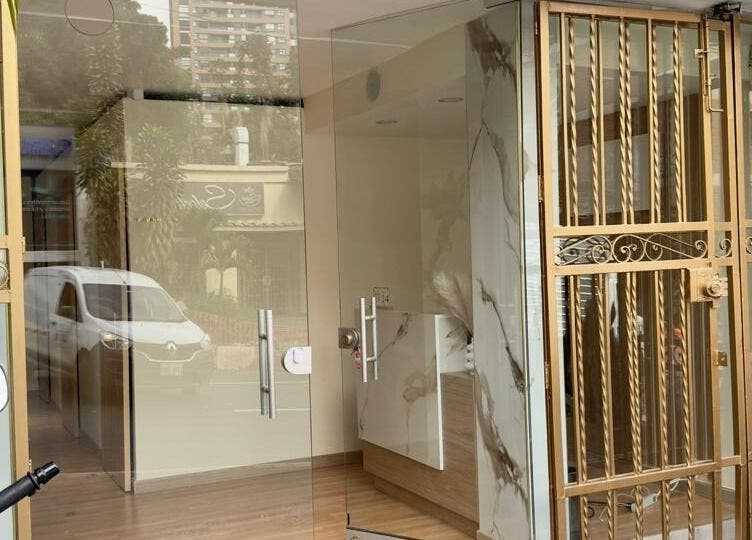 Entrada de Nudeskinwaxing, Medellín, Antioquia, CO con puerta dorada y vidrio elegante.