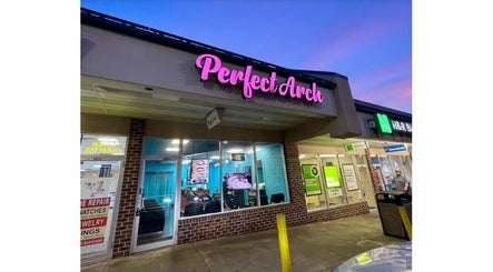 Brow Art 23 salon exterior during twilight in Reisterstown, Maryland, US with glowing signage.
