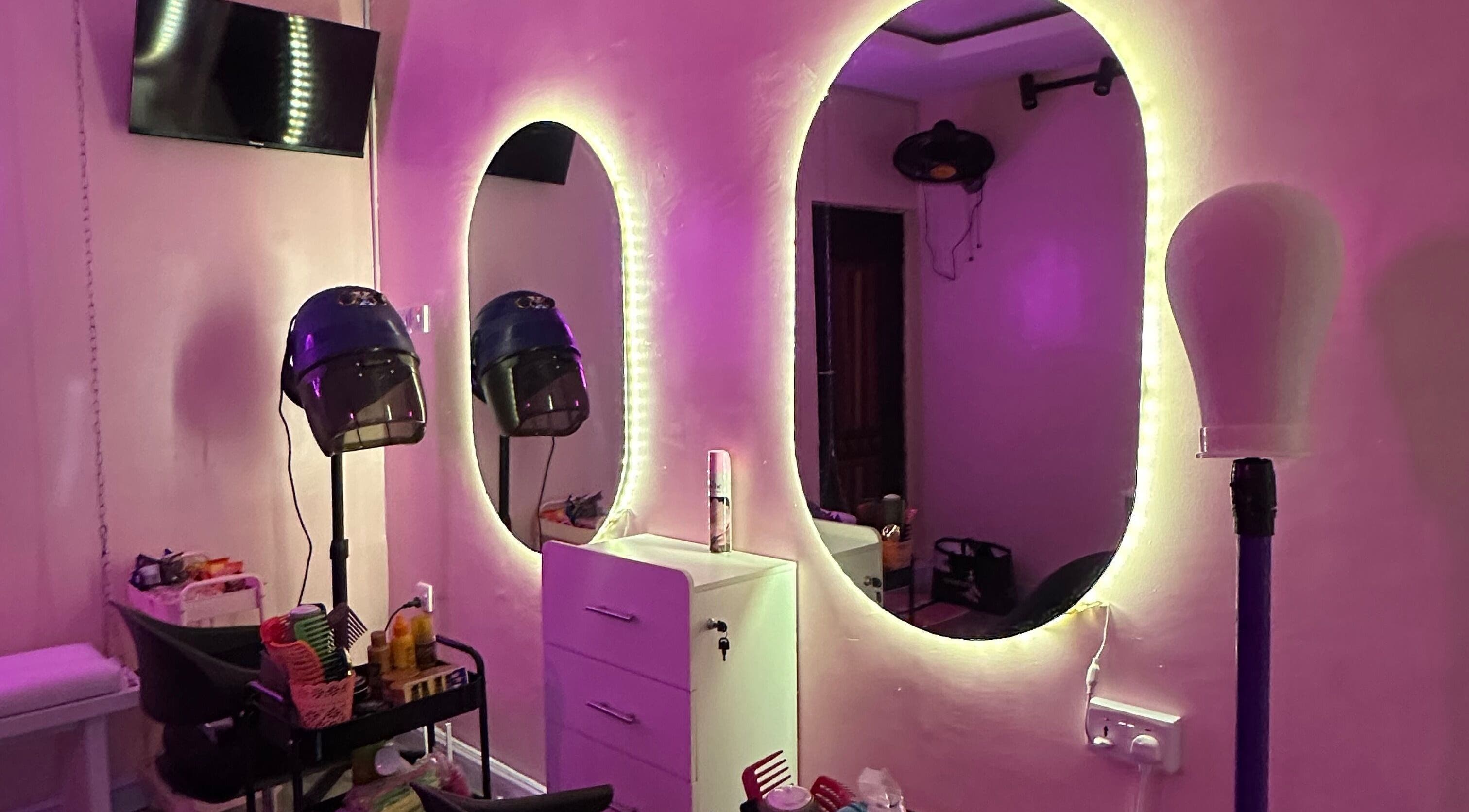 Elegant beauty salon setup at At Cake’s, Lagos, Lagos, NG featuring illuminated mirrors and modern hair styling tools.