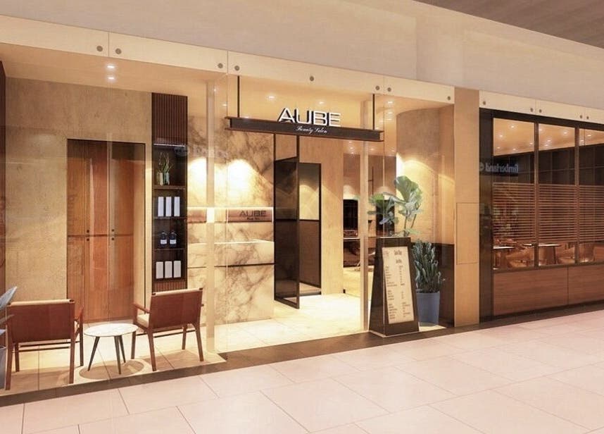 Entrance of AUBE Marina Square, a chic beauty venue in Singapore, SG with stylish decor and warm lighting.
