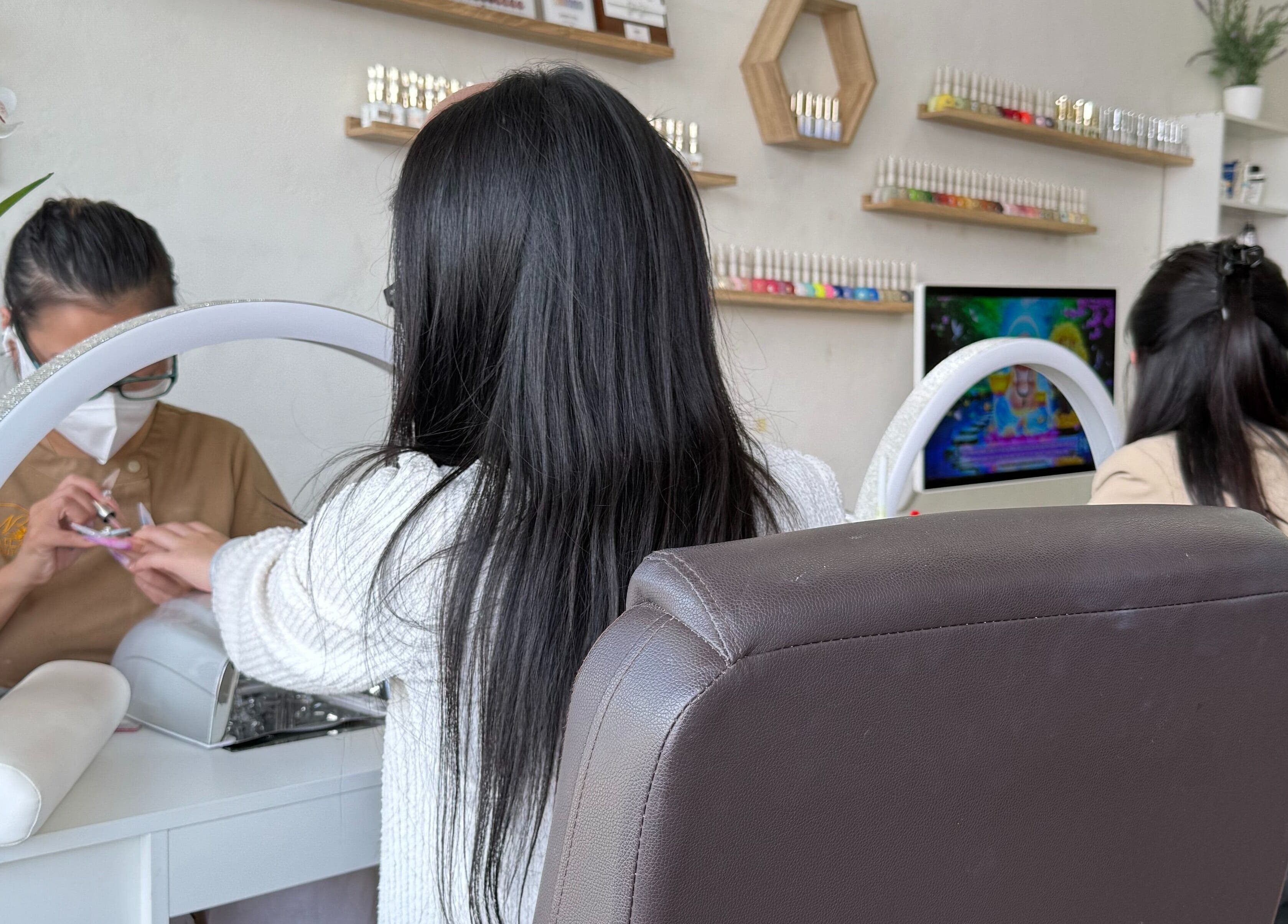 Client enjoying a nail treatment at Naila Beauty, Canley Heights, New South Wales, AU. Elegant salon setup and services.