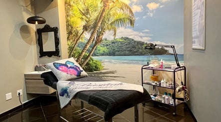Relaxation room at Basiliah Beauty Salon Tan Can in Pretoria, Gauteng, ZA with tropical beach mural and treatment bed.