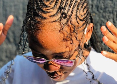 Intricate braided hairstyle at BRILLO BONITA EMPIRE, Windhoek, Khomas Region, NA, capturing sunlight.