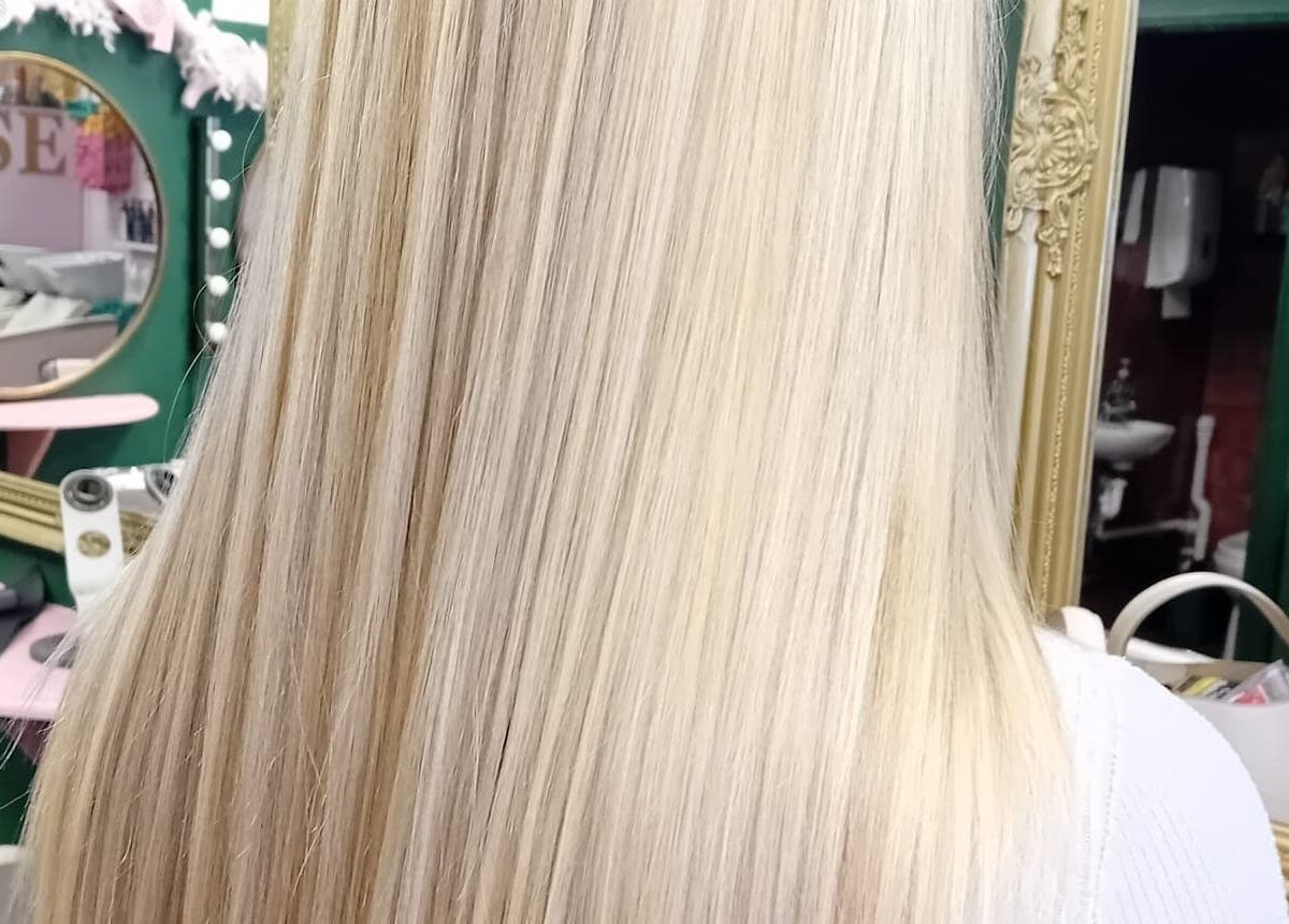 Blonde hair styled at Beard and Blow Hairdressing Salon in Romford, England, GB, reflecting in a vintage mirror.