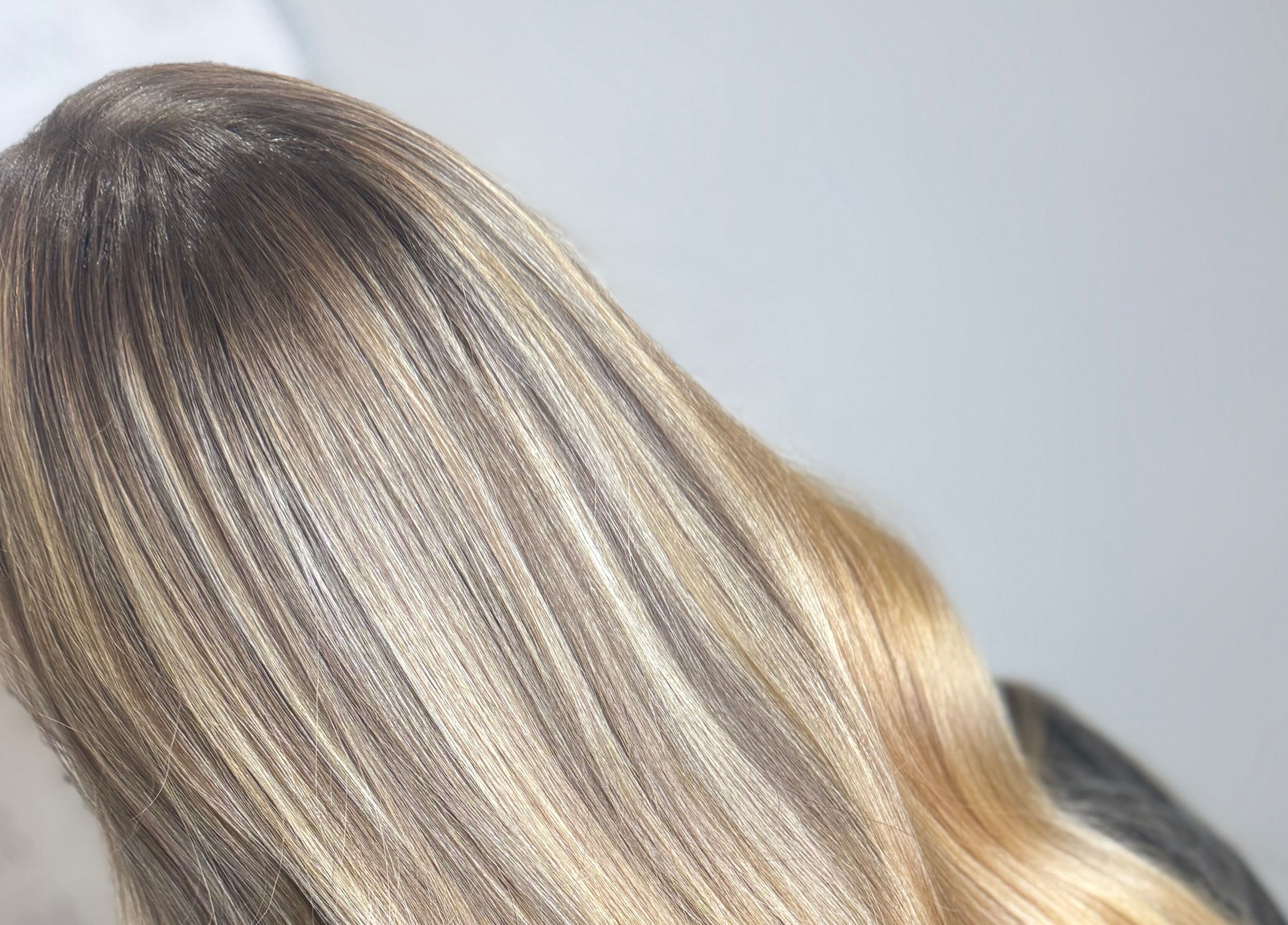 Glossy blonde hair styled at Emily V Hair in Coggeshall, England, GB, showcasing expert coloring technique.