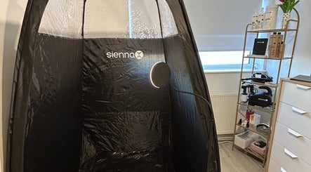 Sienna tanning booth at Ell’s Glow Studio, Galley Common, England, GB with beauty products on display.
