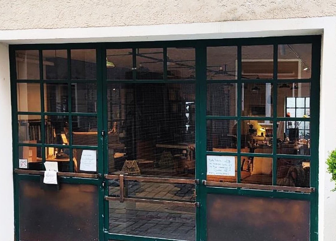 Eingang von T.A. Nagelstudio in Augsburg, Bayern, DE mit grüner Tür und Topfpflanzen.