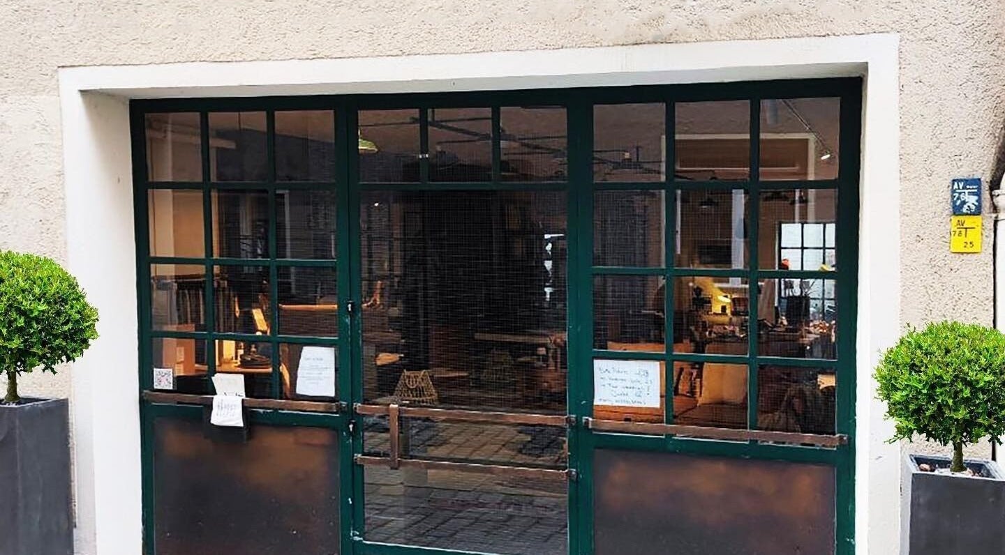 Eingang von T.A. Nagelstudio in Augsburg, Bayern, DE mit grüner Tür und Topfpflanzen.