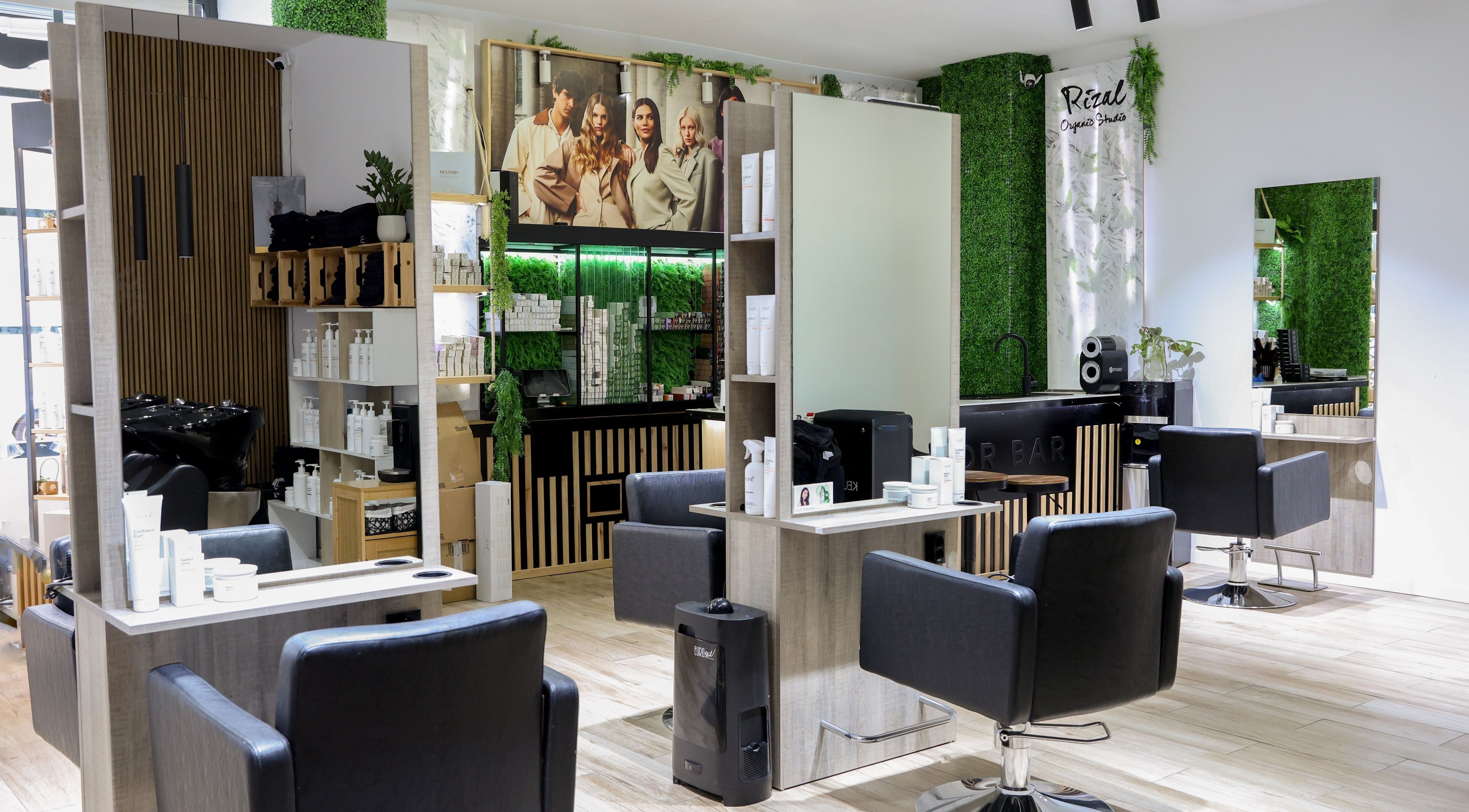 Salón moderno y elegante en Rizal Organic Studio, Madrid, Comunidad De Madrid, ES, con sillas negras y vegetación.