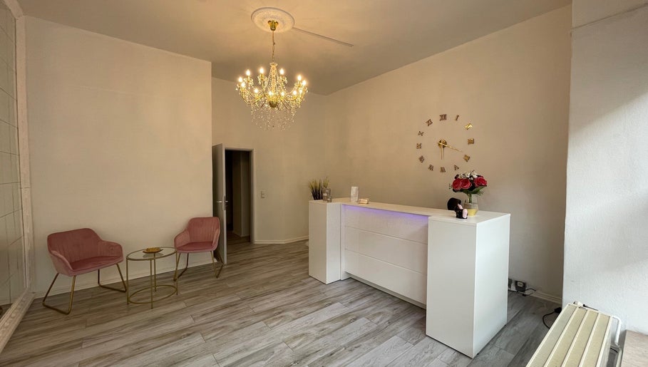 Eleganter Empfangsbereich bei Zeus & Ruby Beauty Spa in Berlin, Berlin, DE mit Kronleuchter und weißem Tresen.