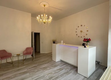 Eleganter Empfangsbereich bei Zeus & Ruby Beauty Spa in Berlin, Berlin, DE mit Kronleuchter und weißem Tresen.