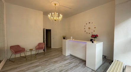 Eleganter Empfangsbereich bei Zeus & Ruby Beauty Spa in Berlin, Berlin, DE mit Kronleuchter und weißem Tresen.