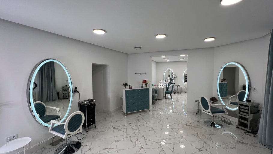 Chic interior of Friseursalon Grande Grunewald, Berlin, Berlin, DE, with modern decor and illuminated mirrors.