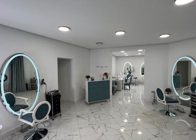 Chic interior of Friseursalon Grande Grunewald, Berlin, Berlin, DE, with modern decor and illuminated mirrors.