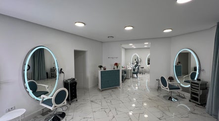 Chic interior of Friseursalon Grande Grunewald, Berlin, Berlin, DE, with modern decor and illuminated mirrors.