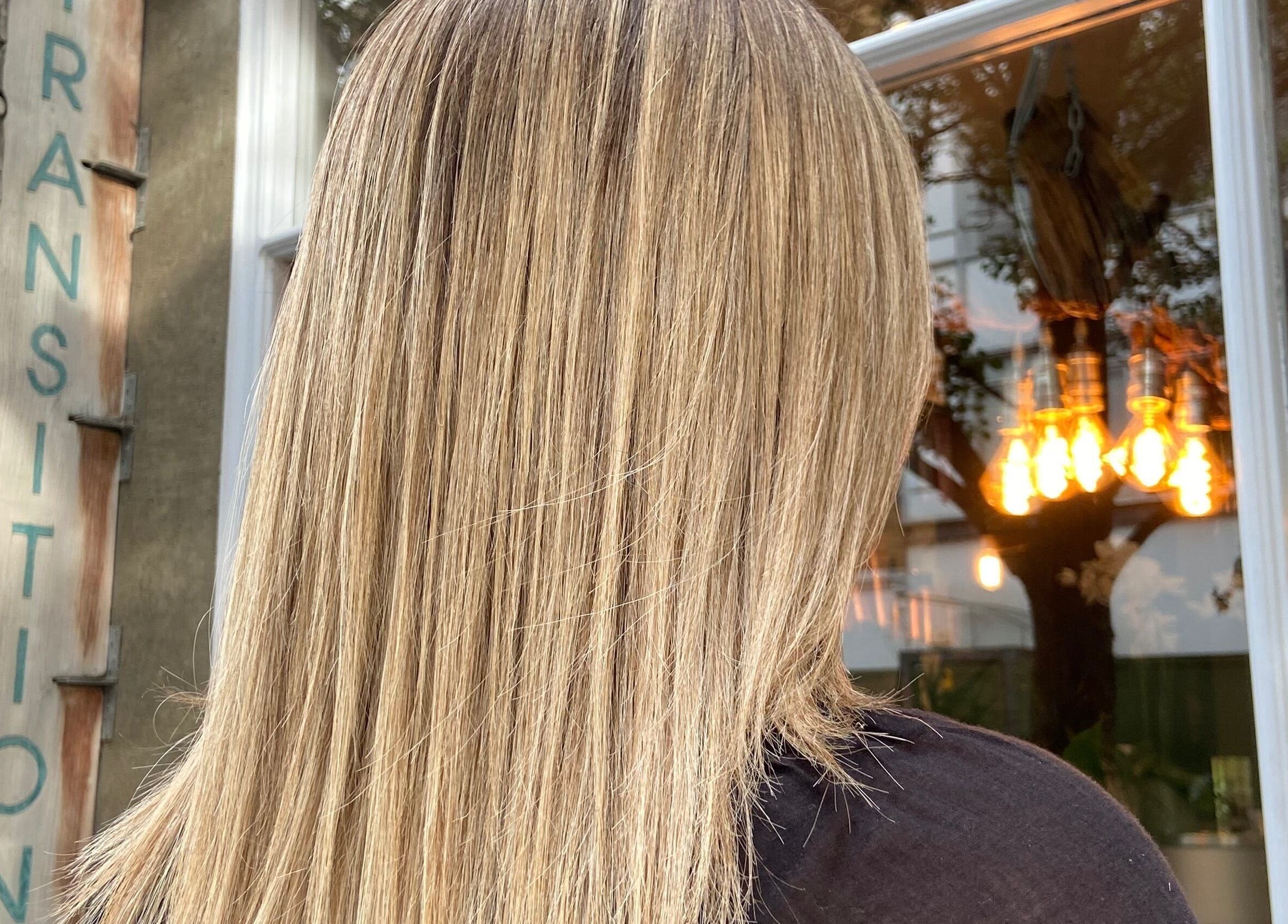 Blonde hair shines outside Transition Salon, London, England, GB, showcasing expert hair styling.