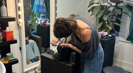 Hairdresser styling a client's hair at KS Hair Salon, Windsor, England, GB.