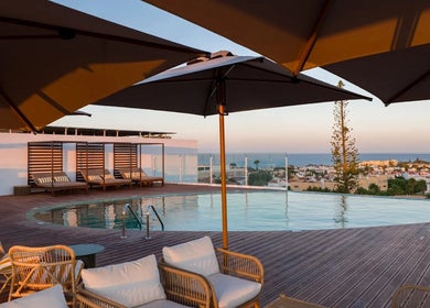 Relaxing poolside view at Slow Living Spa - Ananea Castelo Suites Hotel in Albufeira, PT, overlooking the ocean.