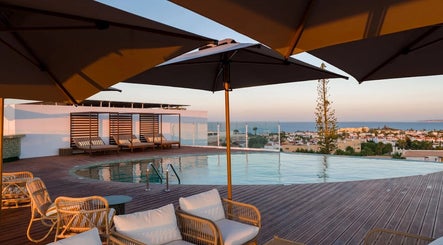Relaxing poolside view at Slow Living Spa - Ananea Castelo Suites Hotel in Albufeira, PT, overlooking the ocean.
