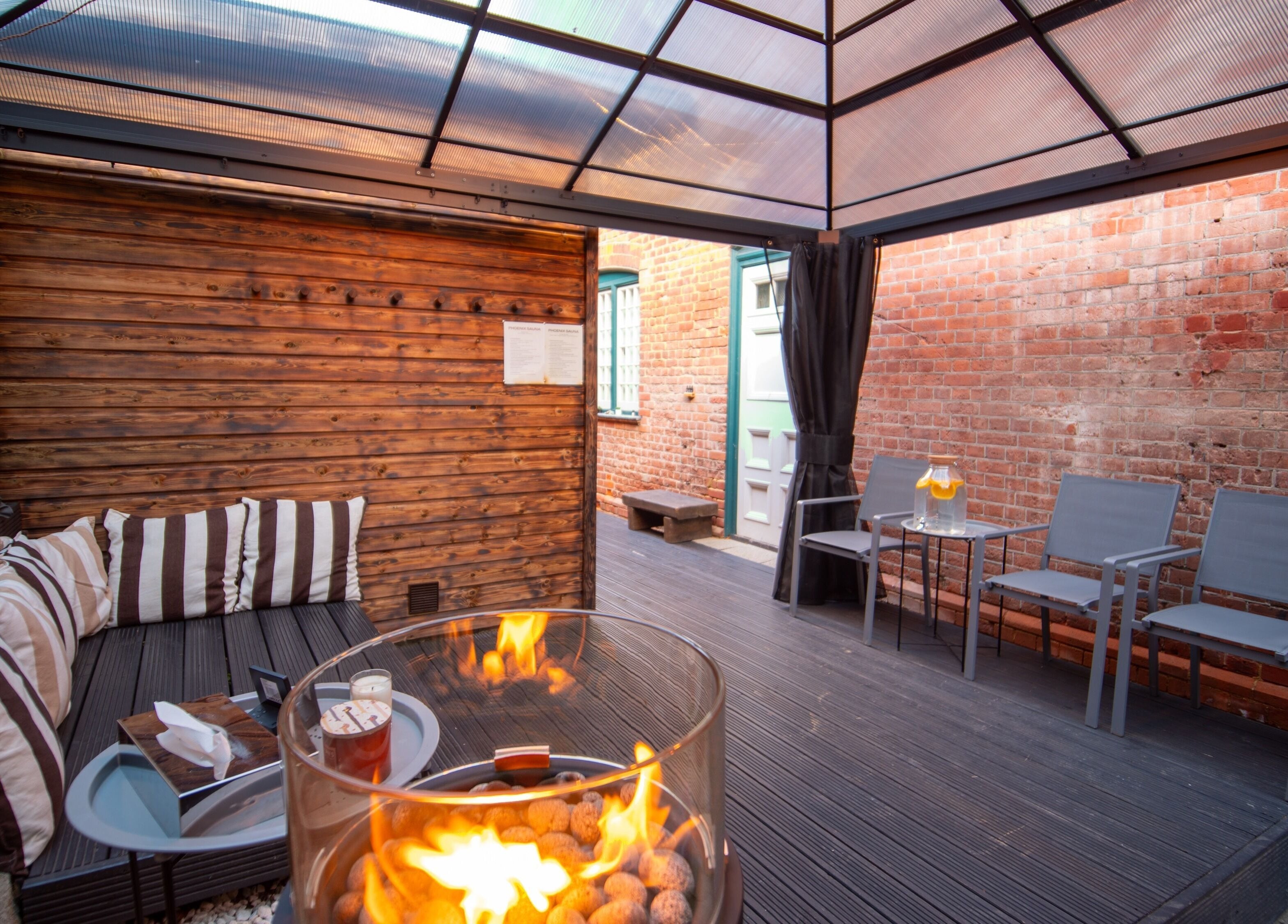 Outdoor seating with fireplace at Phoenix Burning Sauna in London, England, GB. Perfect relaxation spot.