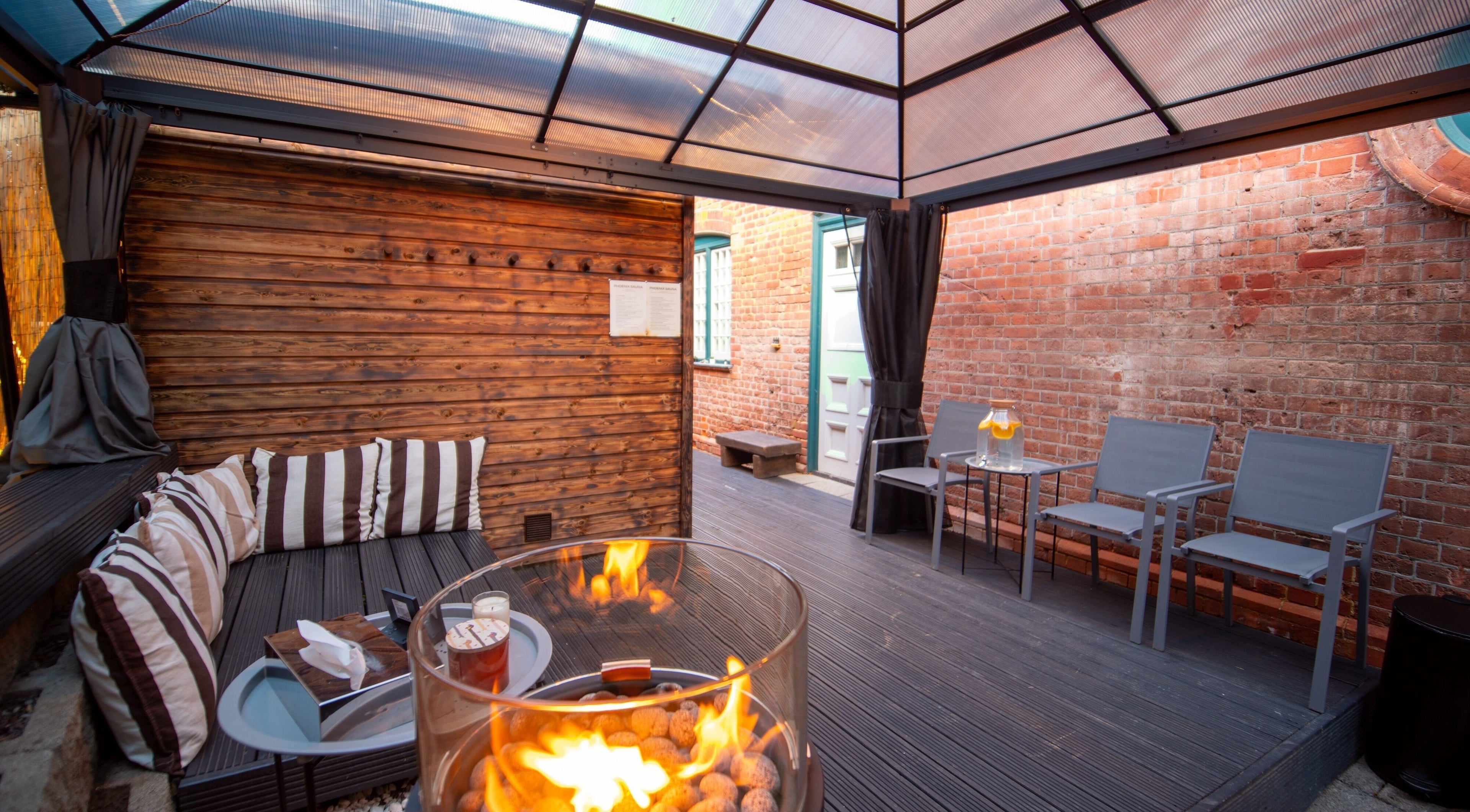 Outdoor seating with fireplace at Phoenix Burning Sauna in London, England, GB. Perfect relaxation spot.