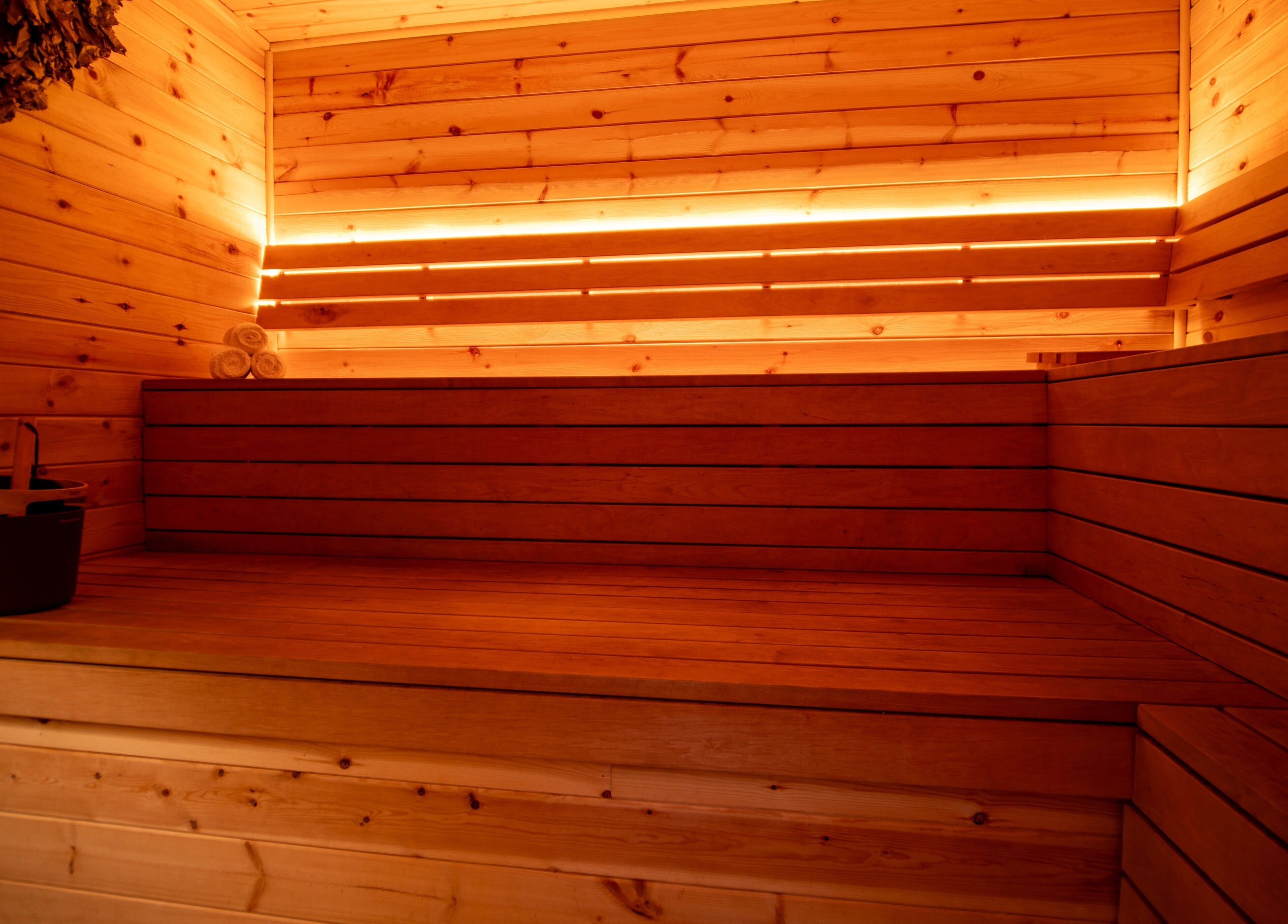 Cozy interior of Phoenix Burning Sauna, London, England, GB, with wooden benches and soft lighting.