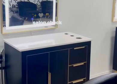 Modern styling station at Creative Hands Salon, Tampa, Florida, US, featuring sleek black cabinetry.