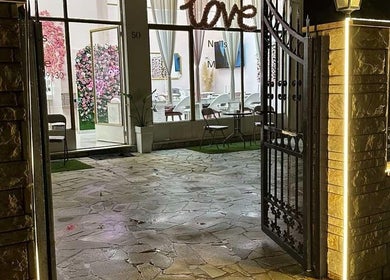 Η είσοδος του Love nails and more Argiroupoli στην Αργυρούπολη, GR, φωτισμένη τη νύχτα.