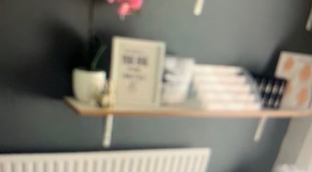 Elegant shelf with decor at Skin & Laser Aesthetics, Smethwick, England, GB. Features a pink orchid and framed art.