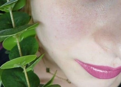 Bliska twarz z różowymi ustami i zielonymi liśćmi w Lashes Asi, Beverwijk, Noord-holland, NL.