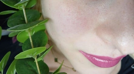 Bliska twarz z różowymi ustami i zielonymi liśćmi w Lashes Asi, Beverwijk, Noord-holland, NL.