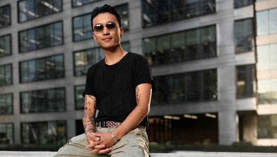 Osoba w okularach przeciwsłonecznych przed budynkiem przy Monkey, Warszawa, Województwo Mazowieckie, PL.