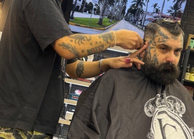 Klient z brodą i tatuażem na strzyżeniu w salonie Monkey, Warszawa, Województwo Mazowieckie, PL.