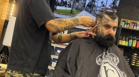 Klient z brodą i tatuażem na strzyżeniu w salonie Monkey, Warszawa, Województwo Mazowieckie, PL.