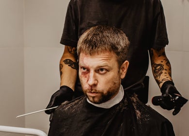 Mężczyzna podczas strzyżenia w salonie Monkey, Warszawa, Województwo Mazowieckie, PL.