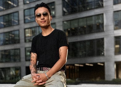 Osoba siedząca przed budynkiem Monkey w Warszawa, Województwo Mazowieckie, PL, emanująca spokojem.