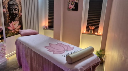 Relaksujący gabinet InMassage w Szczecinie z nastrojowymi świecami, obrazem Buddy i estetycznym wystrojem.