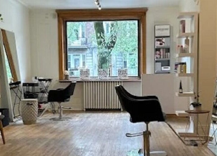 Espace élégant chez Karima Signature.ca, Montréal, Québec, CA, avec des chaises de salon et des étagères bien garnies.